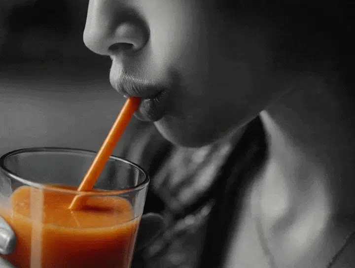 Woman sipping an Xstraw smoothie straw
